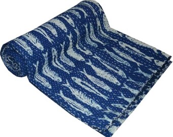 May include: A blue and white kantha quilt with a fish pattern. The quilt is rolled up and the fabric is soft and textured.