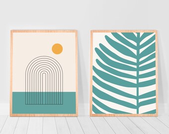 May include: Two framed prints with abstract designs. The print on the left features a black and white arch shape with a yellow circle above it, set against a cream background. The print on the right features a teal green leaf shape against a white background.