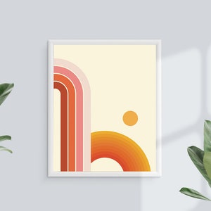 Pu&ograve; includere: Una stampa incorniciata con un design astratto retr&ograve; che presenta una serie di archi sovrapposti di colore arancione, rosa e rosso con un piccolo cerchio arancione nell'angolo in alto a destra.
