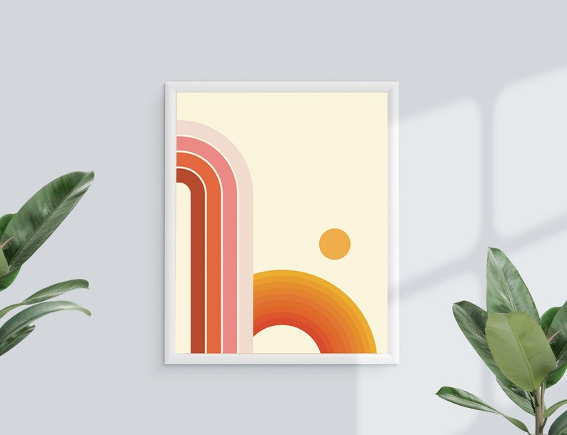Pu&ograve; includere: Una stampa incorniciata con un design astratto retr&ograve; che presenta una serie di archi sovrapposti di colore arancione, rosa e rosso con un piccolo cerchio arancione nell'angolo in alto a destra.