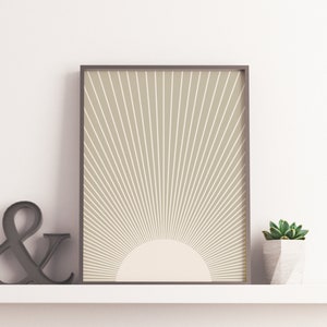 Puede incluir: Una impresi&oacute;n enmarcada con un fondo beige y un dise&ntilde;o de sol blanco. El sol tiene un c&iacute;rculo blanco en el centro.