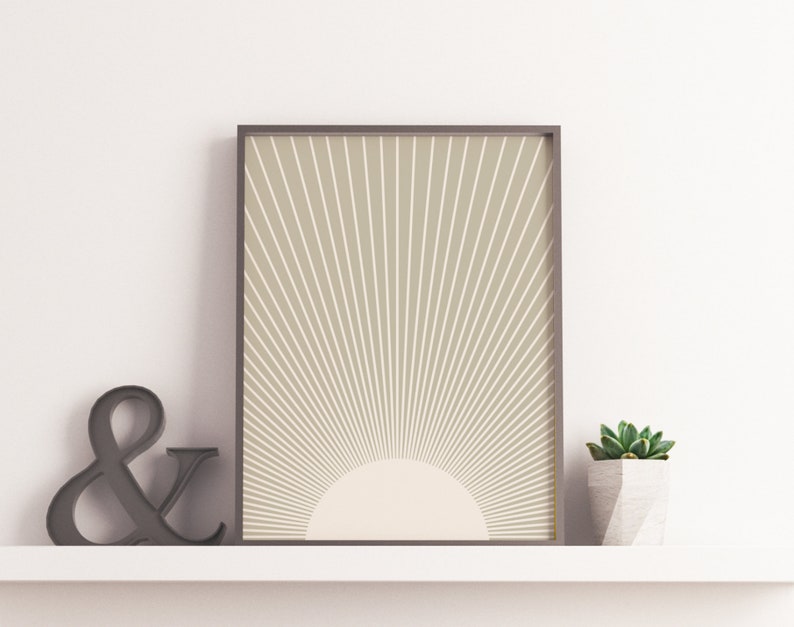 Puede incluir: Una impresi&oacute;n enmarcada con un fondo beige y un dise&ntilde;o de sol blanco. El sol tiene un c&iacute;rculo blanco en el centro.
