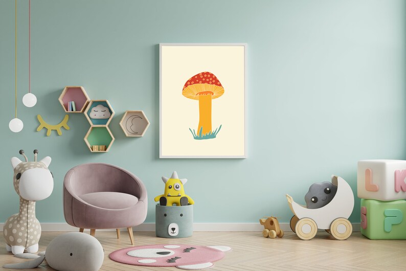 May include: A framed art print showing a mushroom illustration. The mushroom has a red and white spotted cap, an orange stem, and green grass. The artwork is displayed in a child's room with other decorative items, such as a chair and toys.
