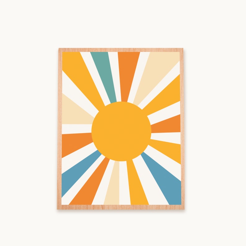 May include: A framed print with a retro sun design. The sun is yellow with orange, blue, and cream rays radiating outward.