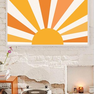 May include: A framed print of a stylized sun with orange and yellow rays against a white background. The sun is a solid yellow circle.