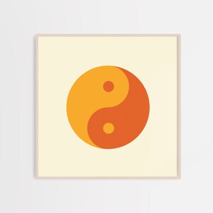 May include: A framed print of a yin yang symbol in orange and yellow on a cream background.