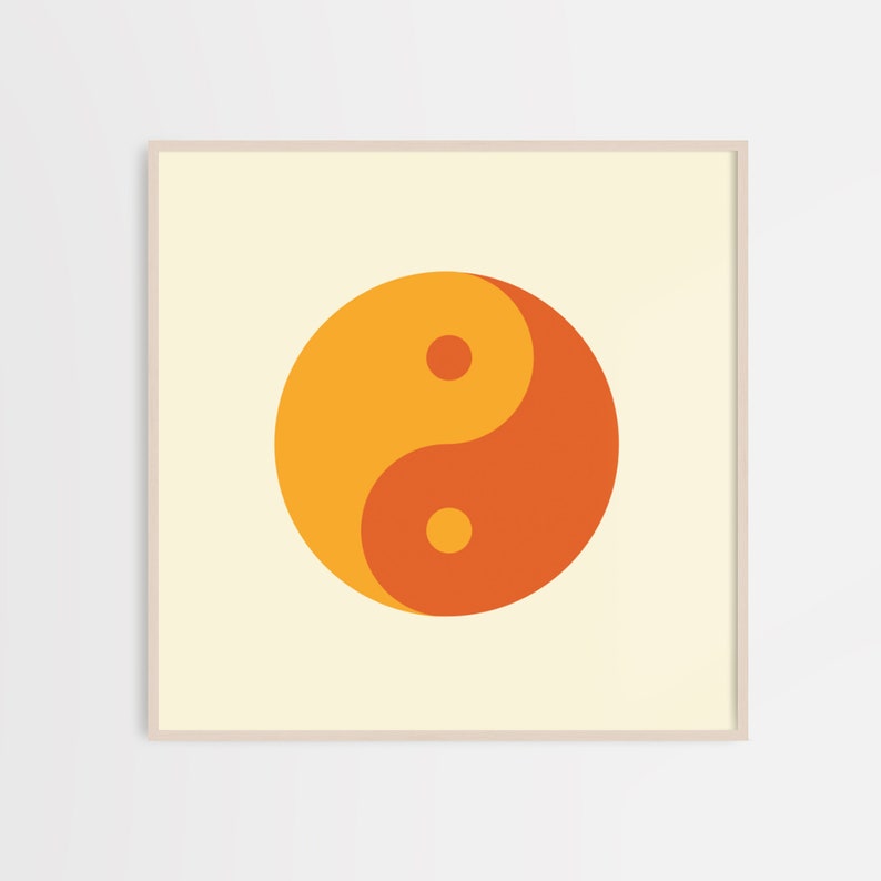 May include: A framed print of a yin yang symbol in orange and yellow on a cream background.