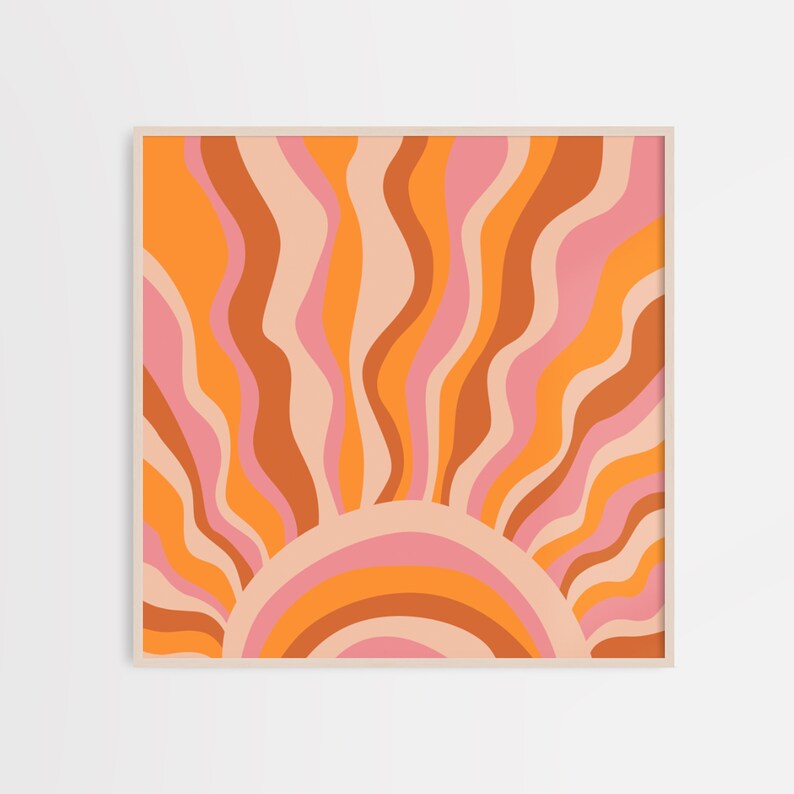 May include: A retro-style sunburst design with wavy lines in shades of orange, pink, and brown. The sunburst is framed in a light wood frame.