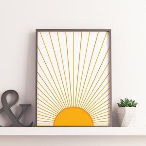 May include: A framed print of a stylized sun with yellow rays on a white background. The sun is a solid yellow circle with a gradient from light to dark yellow.