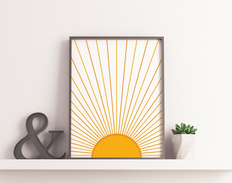 May include: A framed print of a stylized sun with yellow rays on a white background. The sun is a solid yellow circle with a gradient from light to dark yellow.