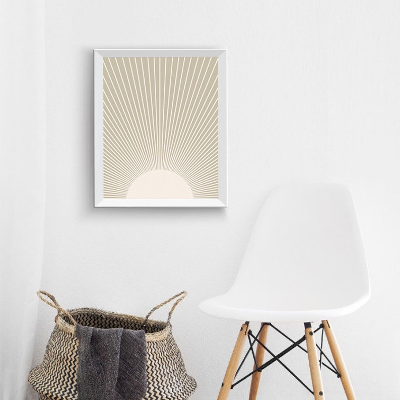Puede incluir: Una impresi&oacute;n enmarcada de un dise&ntilde;o de sol en beige y blanco. El sol est&aacute; formado por l&iacute;neas finas que irradian desde un c&iacute;rculo central. La impresi&oacute;n est&aacute; colgada en una pared blanca.