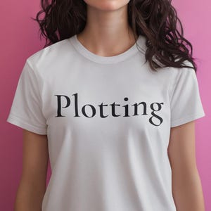 Plotting T-Shirt, Mischievous Humor Tee, Bold Black Text Unisex Shirt Pastel Collection