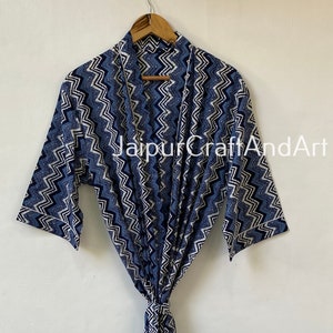 May include: A blue and white patterned cotton robe with a chevron design. The robe has a long sleeve and a tie belt. The text "Jaipur CraftAndArt" is visible on the robe.