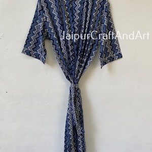May include: A blue and white patterned cotton robe with a chevron design. The robe has a tie belt and long sleeves.