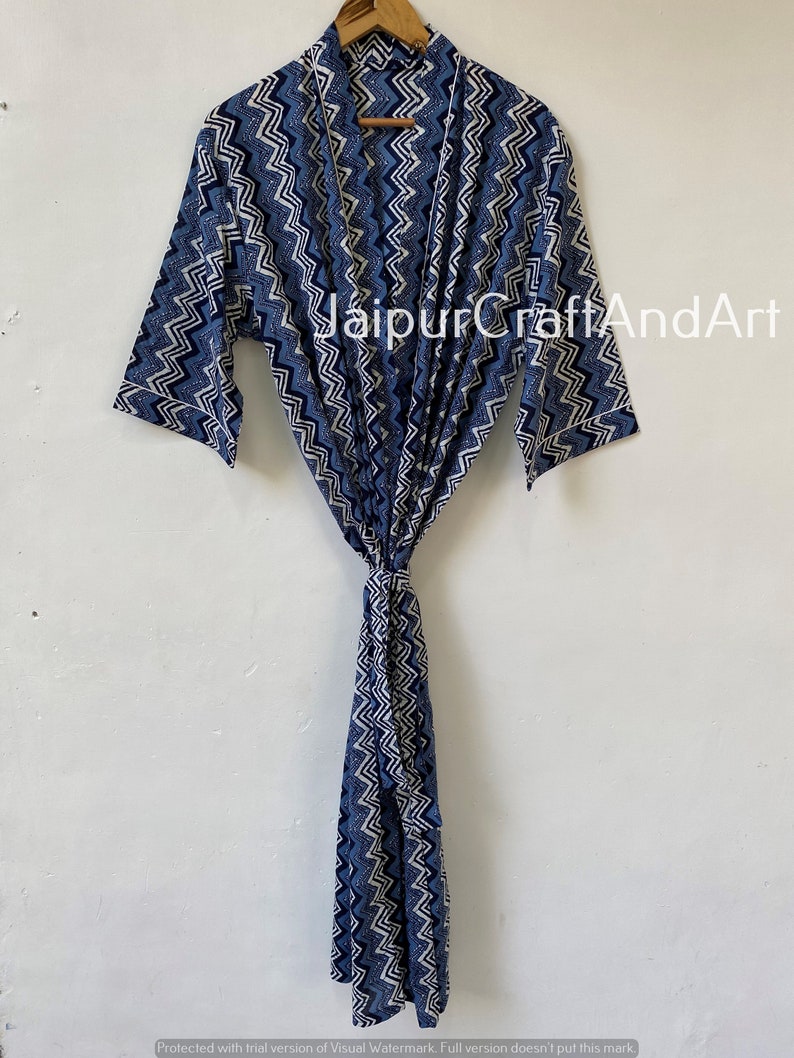 May include: A blue and white patterned cotton robe with a chevron design. The robe has a tie belt and long sleeves.