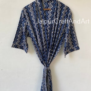 May include: A blue and white patterned cotton robe with a chevron design. The robe has a tie belt and long sleeves.