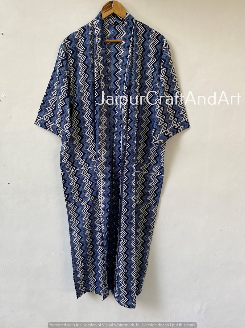 May include: A long, blue and white patterned robe with a chevron design. The robe has a shawl collar and short sleeves. The text "JaipurCraftAndArt" is visible on the robe.
