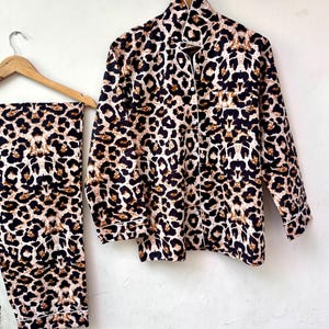 May include: A brown and black leopard print pajama set with a long-sleeved shirt and pants.
