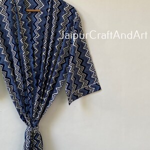 May include: A blue and white patterned robe with a chevron design. The robe has a tie belt and long sleeves.