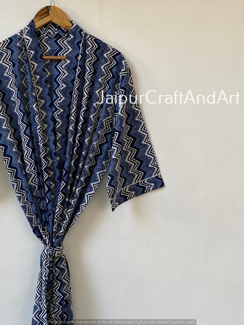 May include: A blue and white patterned robe with a chevron design. The robe has a tie belt and long sleeves.