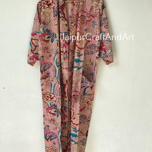 Pu&ograve; includere: Una lunga vestaglia di cotone rosa con stampa floreale in tonalit&agrave; di blu, rosso e bianco. La vestaglia ha un collo a scialle e una cintura da legare. Il testo "JaipurCraftAndArt" &egrave; stampato sulla vestaglia.