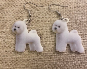 Puede incluir: Un par de pendientes de plata con colgantes de perro Bichón Frisé blanco.