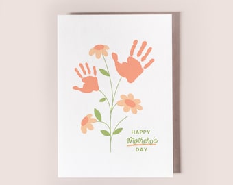 May include: A white card with a green stem and orange handprint flowers. The text "Happy Mother's Day" is written in green cursive.