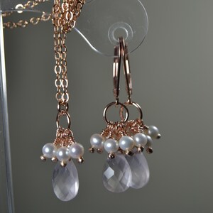 Puede incluir: Juego de joyas de oro rosa con collar y pendientes. El collar tiene una cadena fina con racimos de perlas y una gema rosa facetada en forma de l&aacute;grima. Los pendientes reflejan el dise&ntilde;o, con racimos de perlas y l&aacute;grimas rosas.