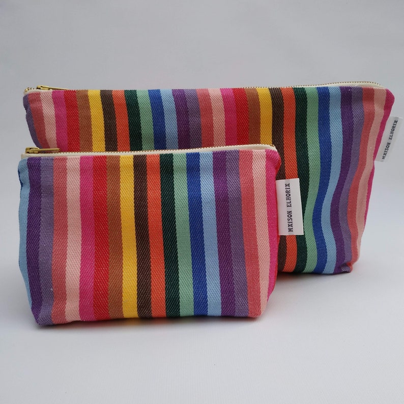 large and small  rainbow wash bags in front of the other with a plain  off-white background