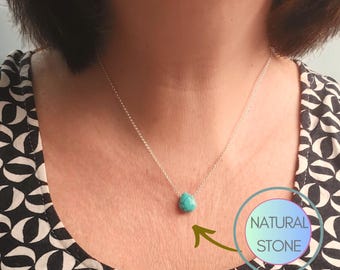 Puede incluir: Un collar de cadena de plata con un colgante de turquesa en forma de lágrima. El colgante está etiquetado como "PIEDRA NATURAL".