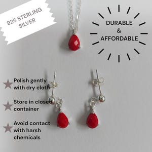 May include: A 925 sterling silver necklace and earring set featuring faceted red teardrop pendants. The image includes text stating 925 STERLING SILVER, DURABLE & AFFORDABLE, and care instructions: Polish gently with dry cloth, Store in closed container, Avoid contact with harsh chemicals.