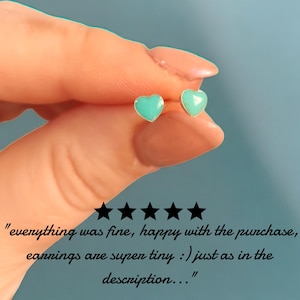 Puede incluir: Pendientes de bot&oacute;n peque&ntilde;os con forma de coraz&oacute;n en color turquesa claro. Los pendientes tienen un borde plateado. La imagen incluye el texto: "everything was fine, happy with the purchase, earrings are super tiny :) just as in the description..."