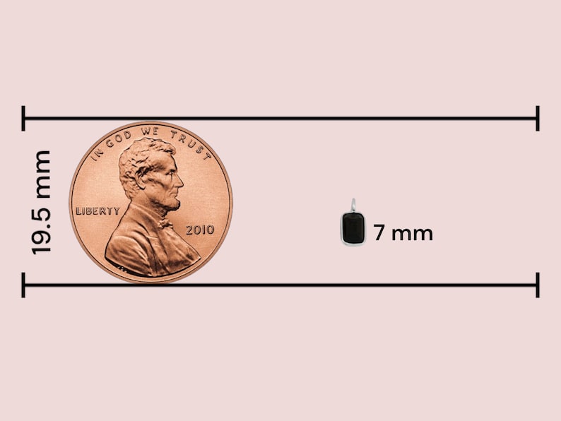 May include: A comparison of sizes between a US penny and a small black rectangular pendant. The penny is 19.5 mm in diameter and the pendant is 7 mm wide.
