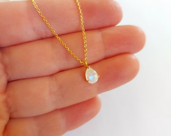 May include: A delicate gold chain necklace with a pear-shaped moonstone pendant.