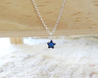 May include: A silver chain necklace with a small blue star pendant.