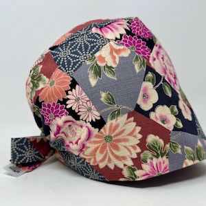 Könnte beinhalten: Patchwork-Mütze mit floralem Muster in Rosa, Orange und Burgunderrot. Die Mütze hat einen gebogenen Schirm und einen Kordelverschluss. Der Stoff weist Blumen- und geometrische Muster auf.