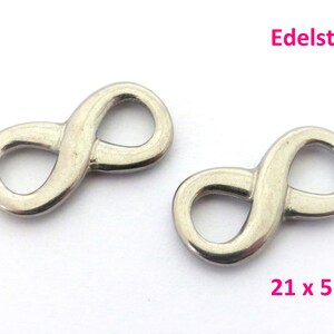 Könnte beinhalten: Zwei silberne Unendlichkeits-Anhänger aus Edelstahl. Jeder Anhänger misst 21 mm x 5 mm.