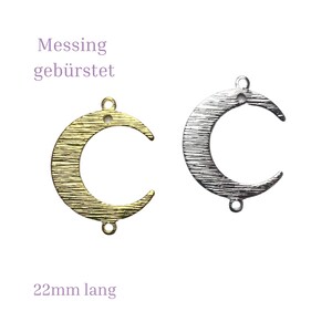 Könnte beinhalten: Zwei halbmondförmige Metall-Anhänger, einer in Gold und einer in Silber, mit gebürsteter Oberfläche. Jeder Anhänger ist 22 mm lang und hat zwei Löcher zum Anbringen an Schmuck.