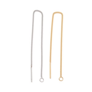 Könnte beinhalten: Zwei Ohrringe zum Einfädeln, einer silberfarben und einer goldfarben, vor weißem Hintergrund. Jeder Ohrring hat eine feine Kette mit einem geraden Stab oben und einem kleinen Ring unten. Die Ohrringe sind zum Durchziehen durch das Ohr konzipiert.