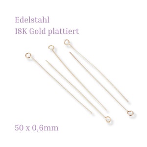 Könnte beinhalten: 50 goldplattierte Edelstahl-Kopfnadeln, jede mit einem Durchmesser von 0,6 mm und einer Länge von 50 mm. Die Kopfnadeln haben eine kleine Schlaufe oben.