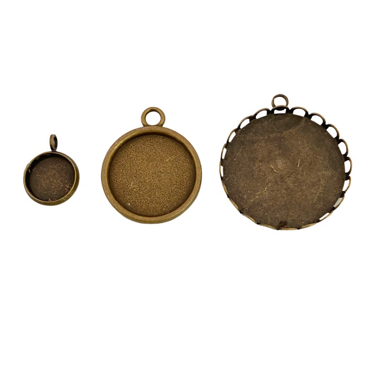 May include: Three antique gold-toned metal pendant trays with round shapes and different sizes. The largest tray has a decorative scalloped edge.