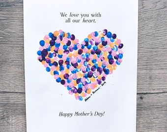 May include: A white card with a heart made of colorful finger paint dots. The text "We love you with all our heart. Happy Mother's Day!" is written on the card. The names "Nolan" and "Roman" are written below the heart.