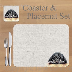 Peut inclure: Un ensemble de dessous-de-verre et de sets de table à thème canin noir et blanc. Le dessous-de-verre présente un chien noir avec la tête reposant sur une surface. Le set de table est blanc avec un chien noir qui sort du coin inférieur droit. Le texte "Coaster & Placemat Set" est imprimé en gris sur un fond brun.