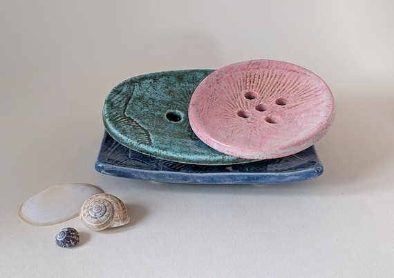 Ceramic soap dish with an embossed fossil design.