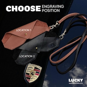 May include: Two leather keychains with a choice of engraving locations marked "Location 1" and "Location 2". The keychains are brown and black and have a gold metal clasp. The text "Choose Engraving Position" is at the top of the image. The image also includes a Porsche logo.