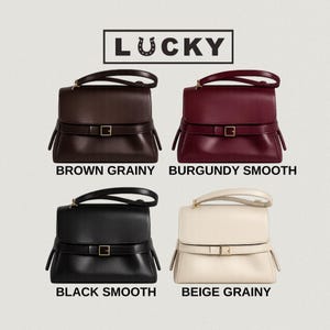 May include: Four handbags labeled LUCKY, featuring a top handle, a flap closure, and a horizontal strap with a gold-tone buckle. The bags are available in brown grainy, burgundy smooth, black smooth, and beige grainy textures and colors.