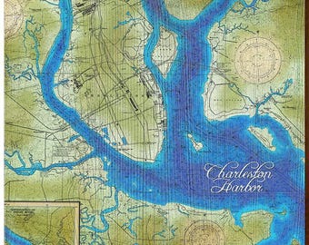 May include: A square wooden wall art piece featuring a nautical chart of Charleston Harbor. The map displays deep blue water channels against a light green landmass, with compass roses and the text Charleston Harbor printed in white.
