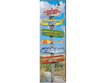 May include: A vertical wooden signpost featuring multiple directional boards labeled Southern Rhode Island Beaches, Charlestown Beach, Green Hill Beach, East Beach, Matunuck Beach, and Narragansett Beach, topped with a small black and white bird.