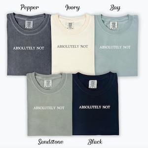 May include: Five t-shirts in different colours, including pepper, ivory, bay, sandstone, and black. Each shirt has the text "ABSOLUTELY NOT" printed on the front.