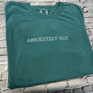 May include: A teal green t-shirt with the text "ABSOLUTELY NOT" embroidered in white.